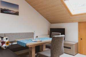 a dining room with a wooden table and chairs at Haus Möslehof in Kauns