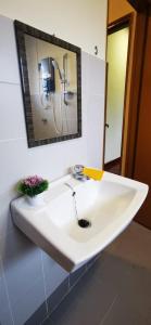 La salle de bains est pourvue d'un lavabo blanc et d'un miroir. dans l'établissement PD Villa 12 Homestay, à Port Dickson