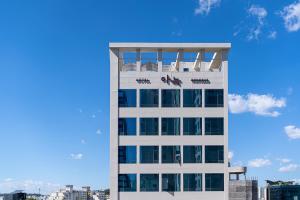 a tall white building with a plane on top of it at The Hyoo Sik ANNK Hong Dae Branch in Seoul