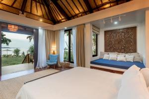 ein Schlafzimmer mit einem Bett und einem großen Fenster in der Unterkunft VILLA JUAN - A Beach Front Villa in General Luna Siargao in General Luna