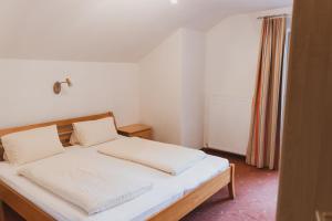 a bedroom with a bed with white sheets at Möslehof in Kauns