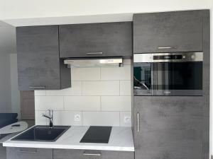 a kitchen with a sink and a stove top oven at Le Petit Navire in La Flotte