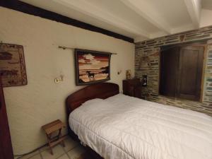 ein Schlafzimmer mit einem Bett und einer Ziegelwand in der Unterkunft Maison La Grée - Maison atypique avec vue sur la nature in Guéméné-Penfao