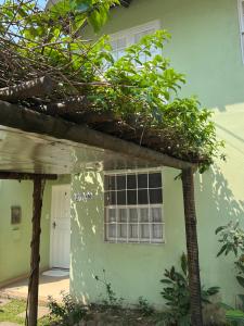 una casa verde con ventana y puerta en Casa verde no centro de Paraty en Paraty