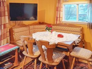 sala de estar con mesa con sillas y TV en One-Bedroom Holiday home in Averøy 1, en Averoy