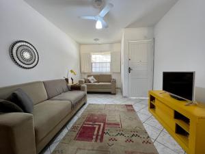 a living room with a couch and a flat screen tv at Casa verde no centro de Paraty in Paraty