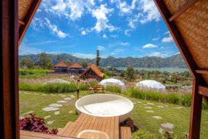 a view of a bath tub in a yard with tents at Segara Camp Kintamani in Kintamani