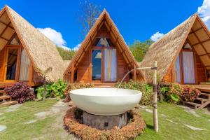 a bath tub in front of a cabin with a house at Segara Camp Kintamani in Kintamani