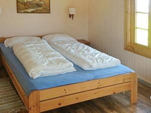 a bed with white sheets and a blue mattress at Six-Bedroom Holiday home in Bud in Bud