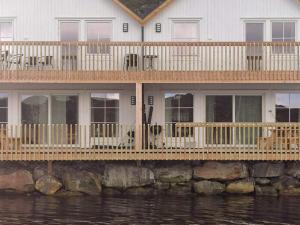 a house with a large deck on the water at 6 person holiday home in Kverva in Dyrvik