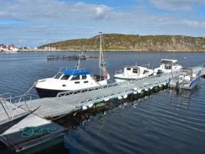 6 person holiday home in Kverva في Dyrvik: مجموعة من القوارب مرساة على رصيف في الماء