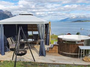 a gazebo with a hot tub next to the water at 10 person holiday home in Lyngseidet in Lyngseidet