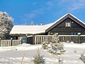 una casa cubierta de nieve con una valla en Holiday home Byrkjelo, en Byrkjelobrua