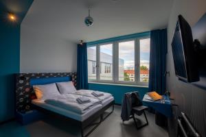德累斯顿MEININGER Hotel Dresden Zentrum的一间带床和大窗户的卧室