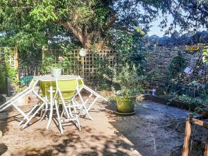 een tafel en stoelen in een tuin bij Apartment Hole 18 3-4 in Nailsworth