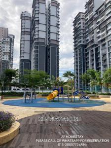 un parque infantil en una ciudad con edificios altos en AF Homestay Islamic Concept at Palmera Residence Nearby Bangi, Kajang, Nilai & KLIA, en Kajang