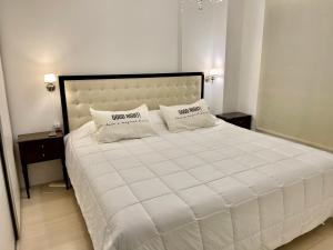 1 dormitorio con 1 cama blanca grande y 2 almohadas en Cañitas 3amb cochera fija techada solo CON RESERVA en Buenos Aires