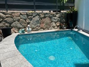 a swimming pool in front of a stone wall at daniela in Eilat