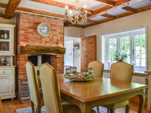 a dining room with a table and a brick wall at Greenbank Cottage in Burley