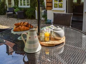 a glass table with a tea set on top of it at Greenbank Cottage in Burley