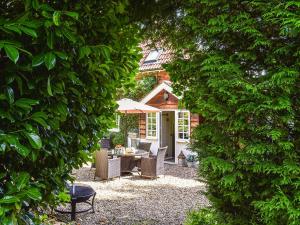 a garden with a table and chairs through two trees at Greenbank Cottage in Burley