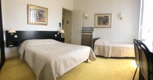 una habitación de hotel con 2 camas en una habitación en Hotel des Mimosas en Juan-les-Pins