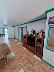 a living room with blue walls and a tile floor at Aitutaki Budget Accommodation in Amuri