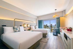 Crowne Plaza Resort Saipan في غارابان: غرفة فندقية بسريرين وبلكونة