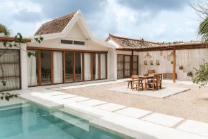 a villa with a swimming pool and a house at Casa Sula Bali in Uluwatu