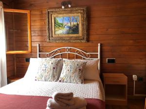ラ・イルエラにあるCabañas De Madera Y Bungalows - Gilmañas 3のベッドルーム1室(ベッド1台付)が備わります。壁に絵が飾られています。