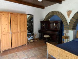 um quarto com uma cama, uma secretária e um piano em Cactus b&b Le casette di Marilena em Pantelleria