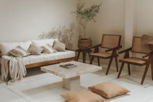 a living room with a white couch and chairs at Casa Sula Bali in Uluwatu