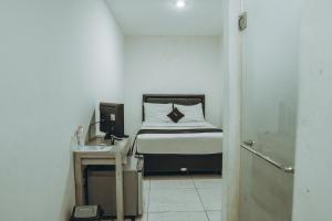 una piccola camera da letto con un letto e una scrivania di DS Colive Siliwangi a Kalibanteng-lor