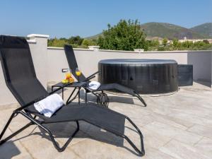two black chairs sitting on top of a patio at Villa Infinity in Kastel Novi