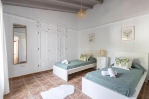 Un dormitorio con dos camas y un espejo. en Villa Damian, en Málaga