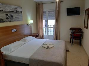 a hotel room with a bed with a towel on it at Sotel Valle Guadiaro in Pueblo Nuevo de Guadiaro