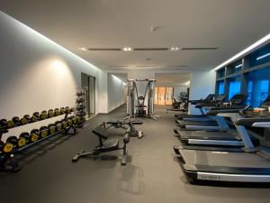 a gym with a row of treadmills and machines at Eaton Residences KLCC by Luna in Kuala Lumpur