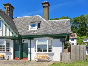 a white house with a bench in front of it at 1 Hamilton Terrace in Lamlash