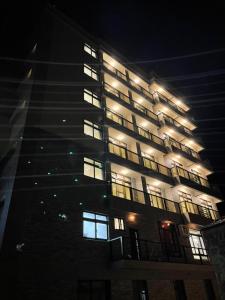 a tall building with lit windows at night at Zhuluowan Club in Nangan
