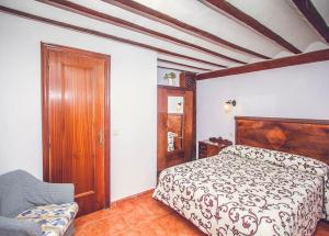 1 dormitorio con 1 cama y 1 silla en Las Casicas del Tío Ángel-A, en Los Alejos