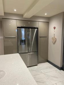 a kitchen with a stainless steel refrigerator at Boho Beach House - Beach location in Bournemouth