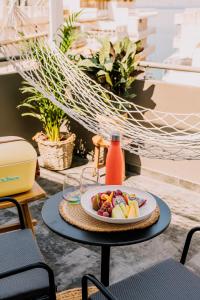 a table with a plate of fruit on it at Dave by the Beach Loutraki, a member of Brown Hotels in Loutraki