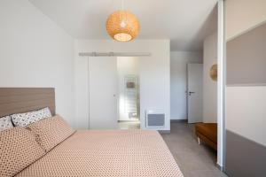 - une chambre blanche avec un lit et une lumière dans l'établissement Villa Piscine Chauffée, 5min du village et Climatisation, à Saint-Saturnin-lès-Apt