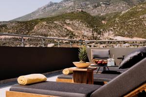 a balcony with two couches and a table and a chair at Dave by the Beach Loutraki, a member of Brown Hotels in Loutraki