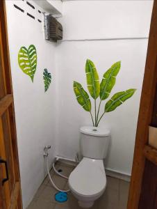 a bathroom with a toilet with a plant on the wall at Maya guest house@coffee in Ko Chang
