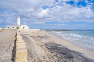 a lighthouse on a sandy beach with the ocean at Appartamento Soleluna in San Cataldo