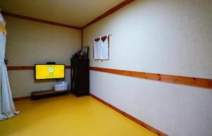 un gimnasio con suelo amarillo en una habitación en Jeonju Hanok Village Beautiful Garden House en Jeonju