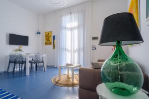 a green glass vase sitting on a table in a living room at Appartamento Soleluna in San Cataldo