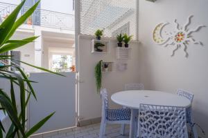a white table and chairs in a room with plants at Appartamento Soleluna in San Cataldo +13 photos