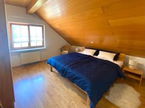a bedroom with a blue bed and a wooden ceiling at Ferienwohnung Böllatblick in Balingen